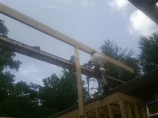 Carpenter setting a ridge beam over a new addition frame — Ice Dam Removal by Roofing Brothers in Culloden