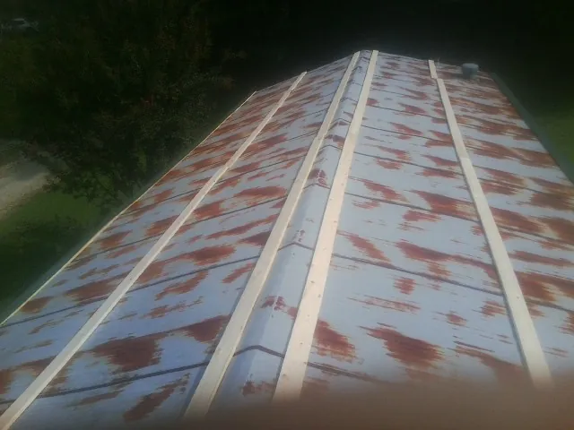 Rusted metal roof panels with new wood purlins before replacement — Storm Damage Roof Repair in Culloden by Roofing Brothers