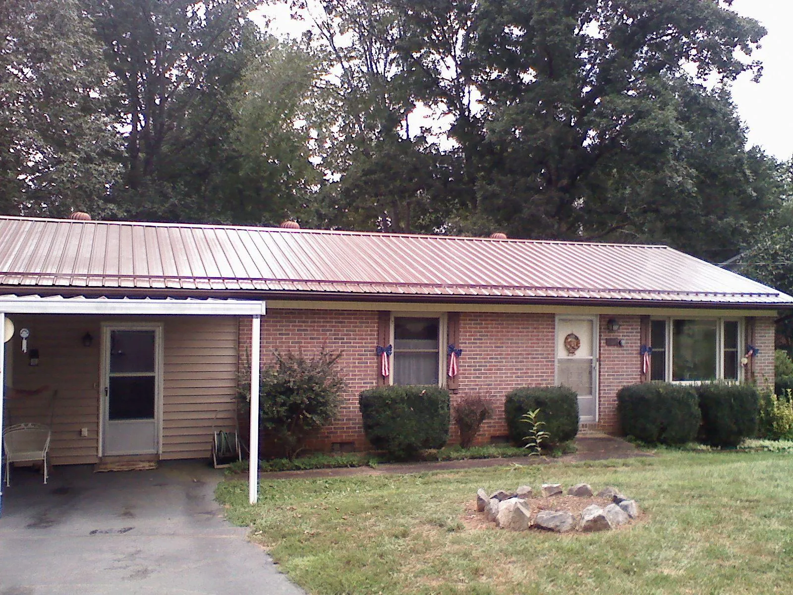 Bronze metal roof and carport on a brick ranch home — Roof Repair work by our crew in Culloden